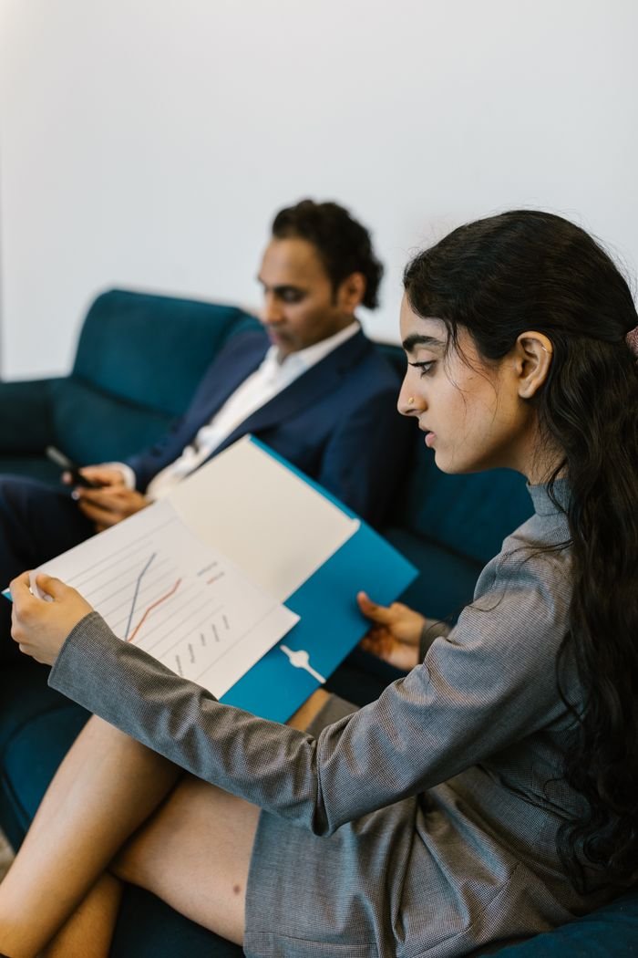 Portfolio Two professionals reviewing data charts in a modern office setting.