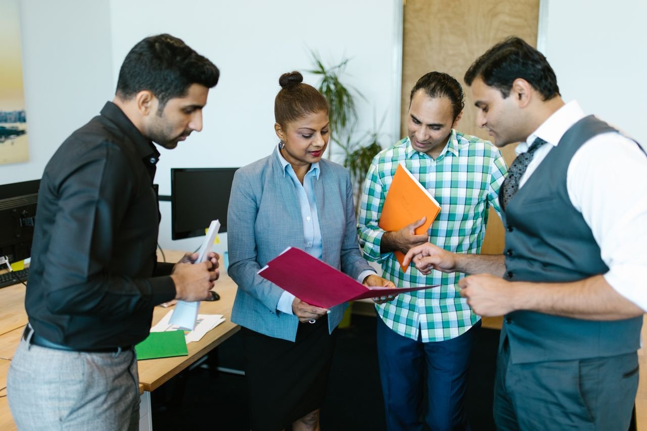 The Art of Drawing Readers In: Your attractive post title goes here Business team engaged in discussion during a meeting in a modern office setting.