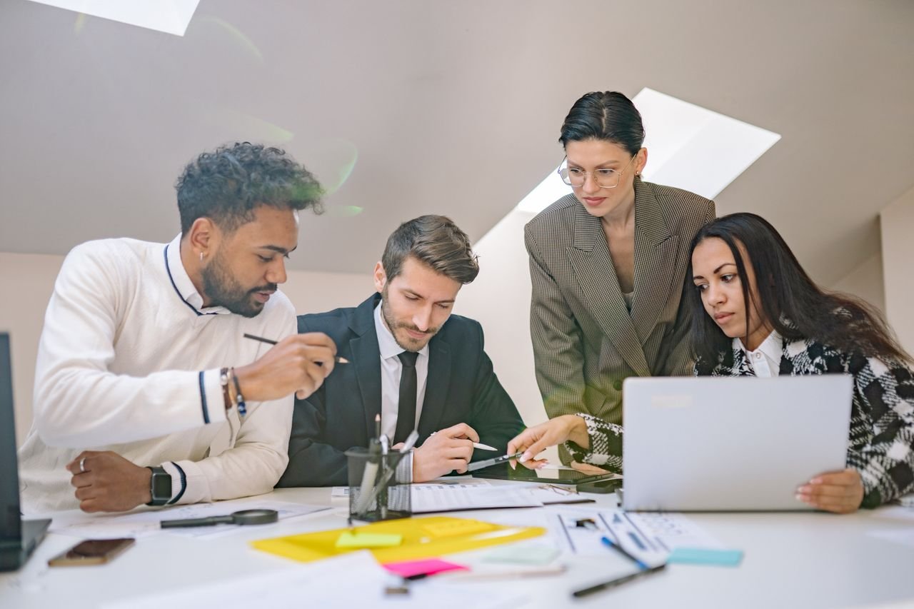 Our Services A diverse group of professionals engaged in collaborative planning in a modern office setting.